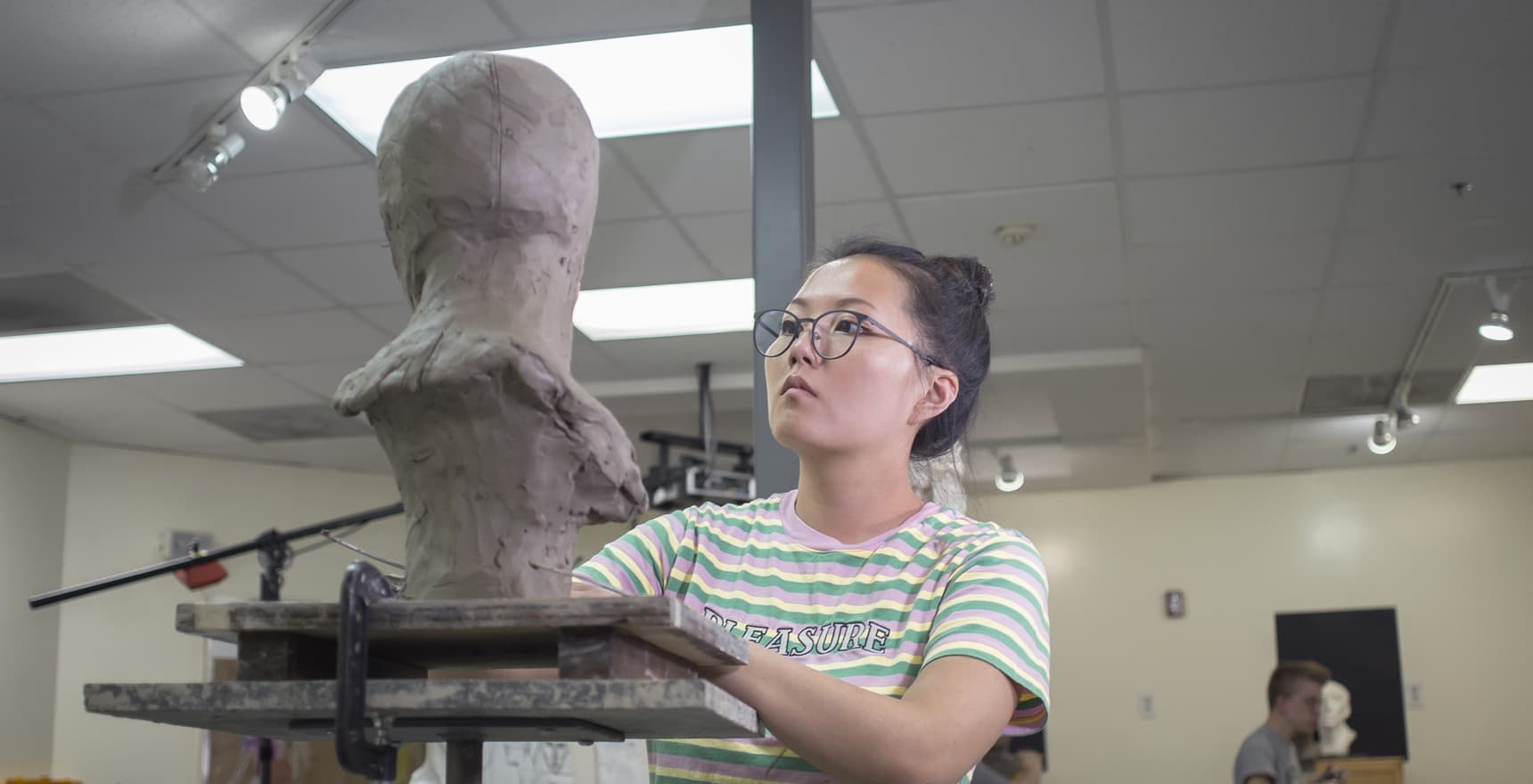 Photo of a sculptor working on the bust of a man